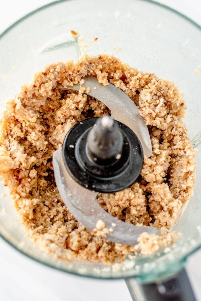 Crumbly dough made of dates, coconut and cashews in a food processor.