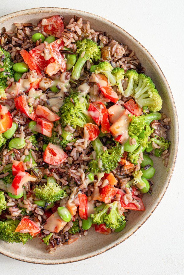 A colourful wild rice and vegetable salad with edamame and raisins.