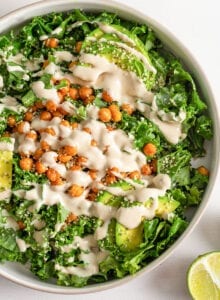 Overhead view of a salad with roasted chickpeas, avocado and a creamy dressing.