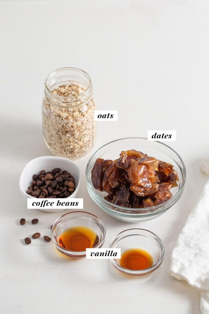 Oats, dates, coffee beans and vanilla in labelled containers.