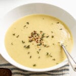Creamy potato leek soup in a bowl topped with rosemary and red pepper flakes.