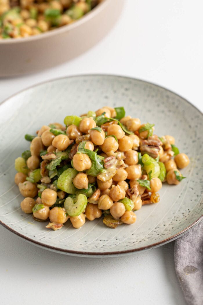 Curried chickpea salad with celery, walnuts and raisins on a plate.