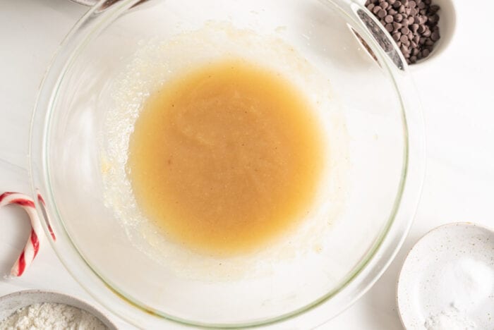 Applesauce mixed with coconut oil and sugar in a mixing bowl.