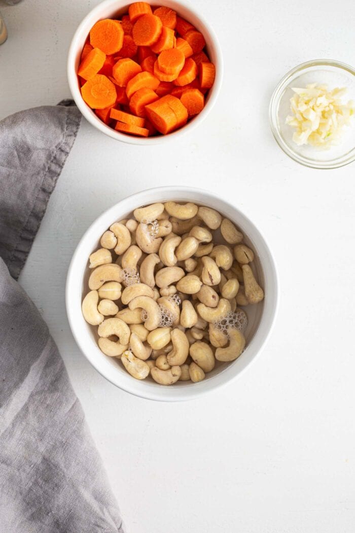Cashews soaking in a small dish of water.