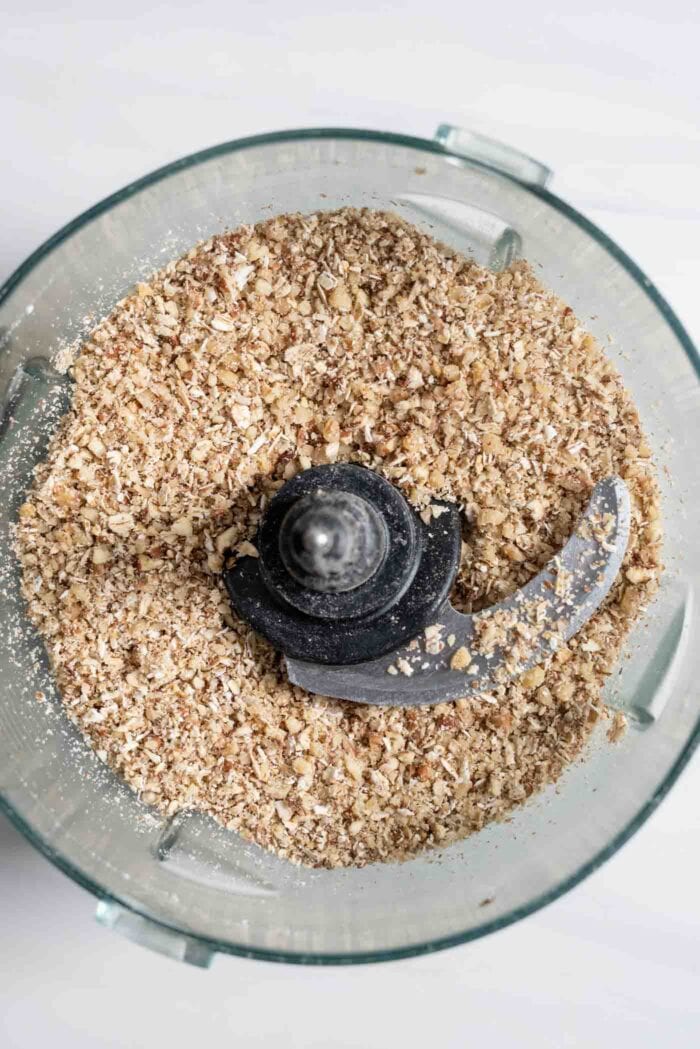 Blended oats and nuts in a food processor.