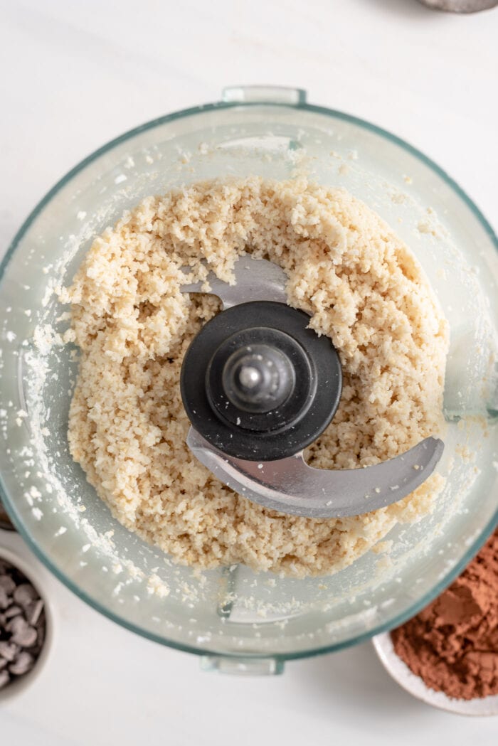 Blended coconut and cashews in a food processor.