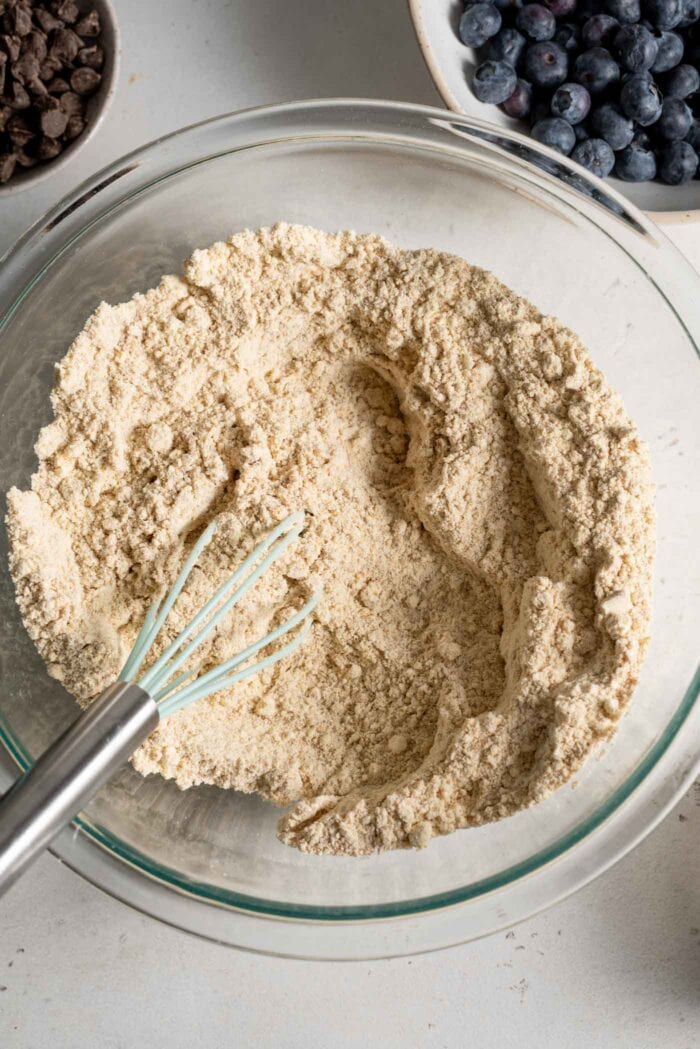 Flour in a mixing bowl with a whisk.