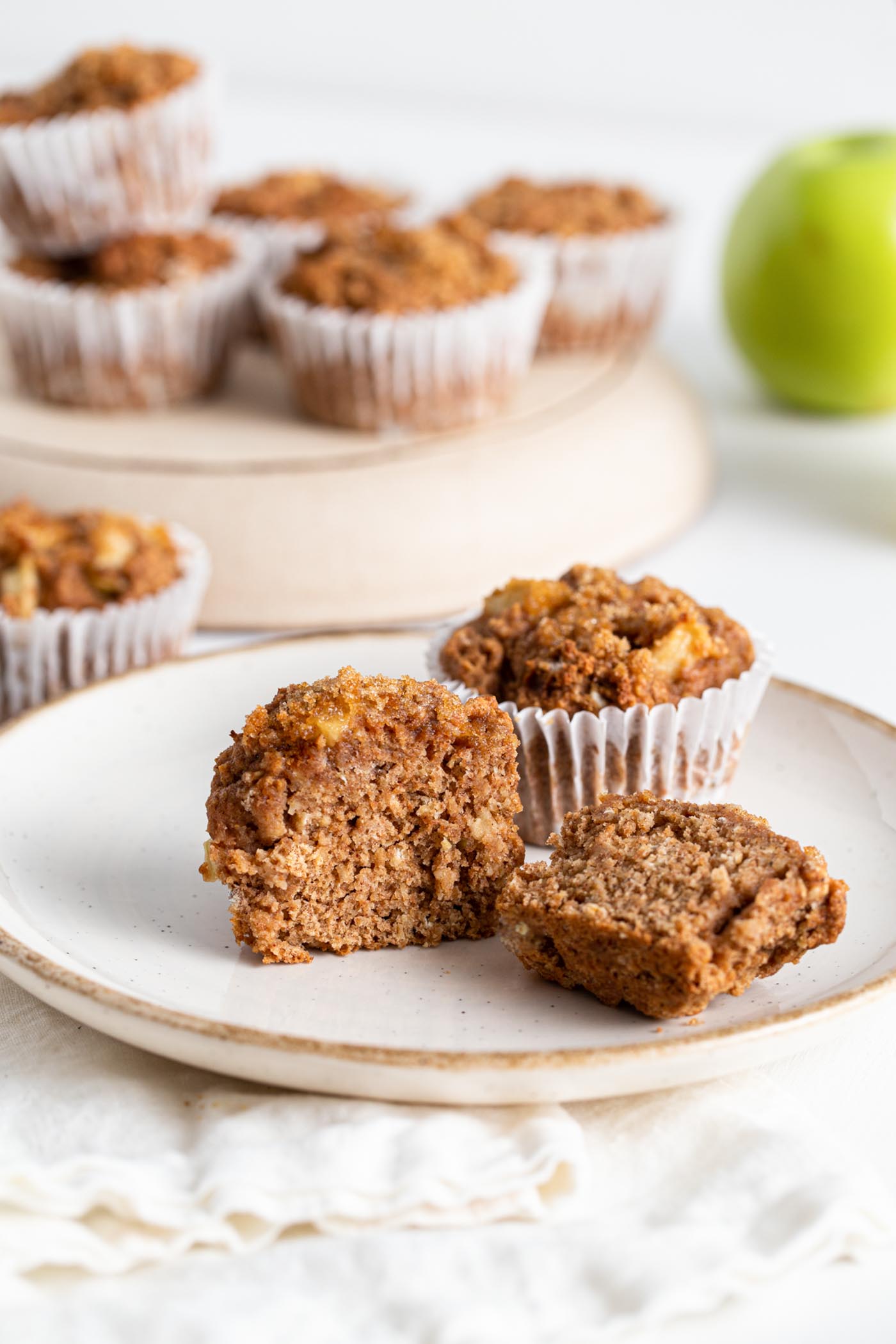 Sliced open applesauce muffin on a plate.