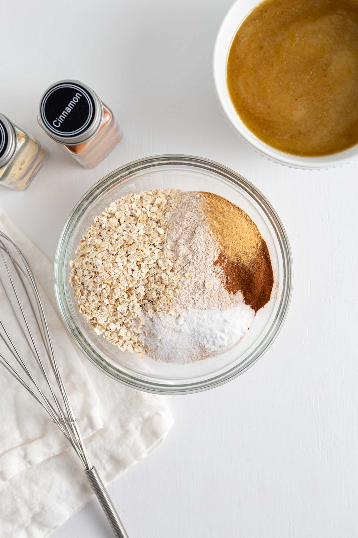 Oats, cinnamon, baking powder, nutmeg and ginger in a bowl.