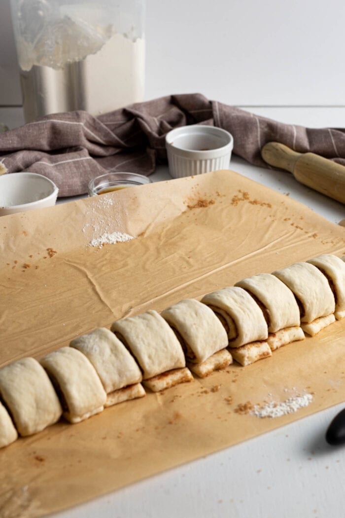 Raw cinnamon roll dough sliced into 12 portions.