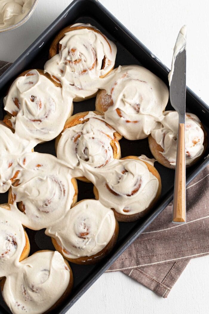 Overhead view of a pan of iced cinnamon rolls.
