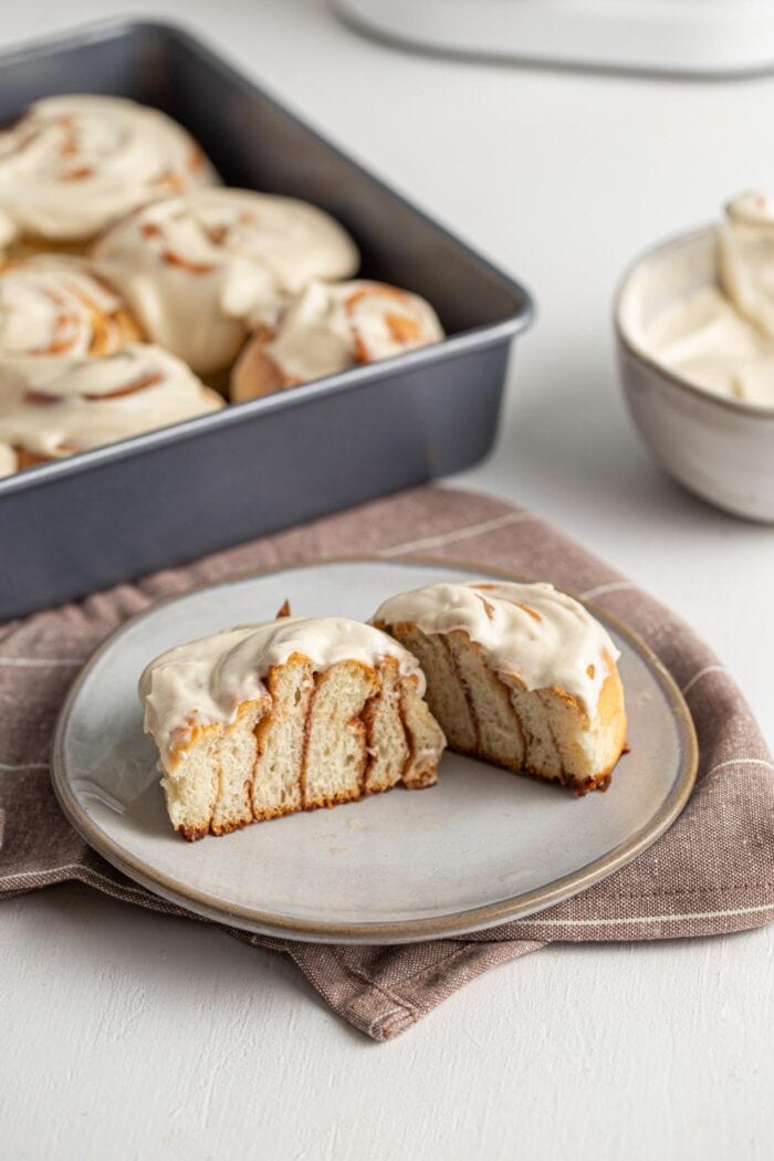 Sliced open cinnamon roll with frosting showing inside texture.