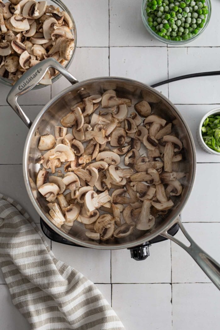 Chopped mushrooms cooking in a skillet.