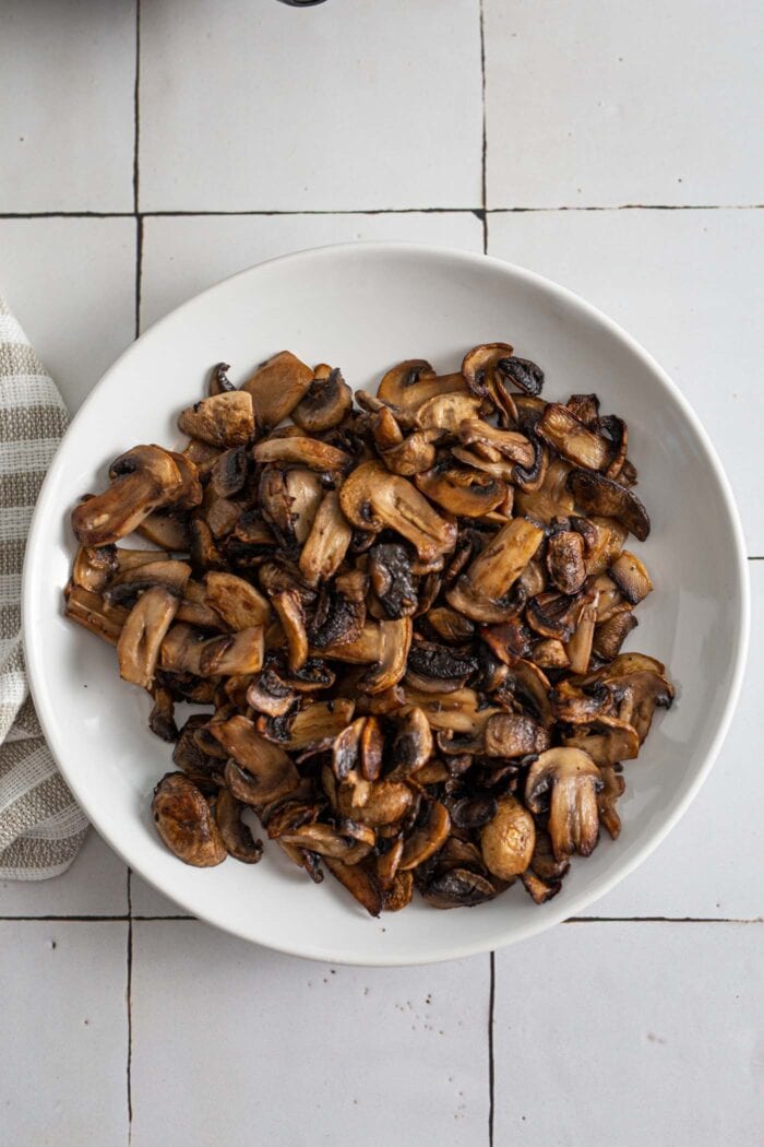 Cooked browned mushrooms on a plate.