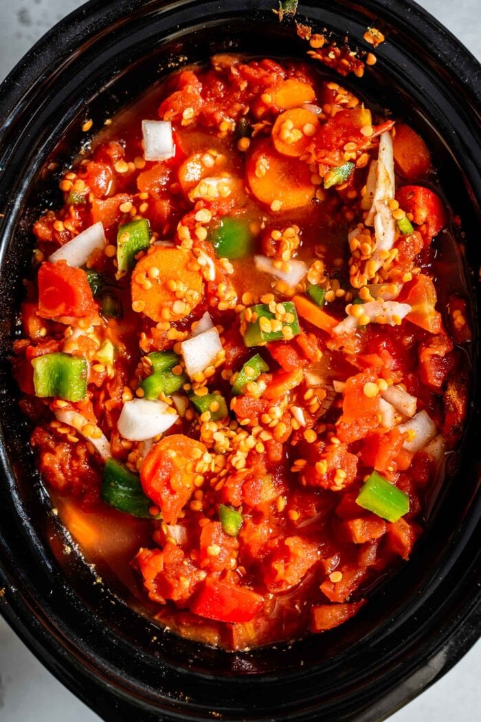 Diced tomatoes, lentils and vegetables in a slow cooker.