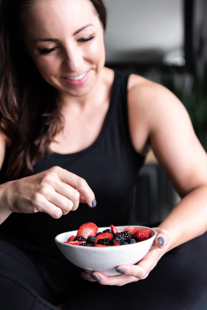 Woman holding a bowl of berries.