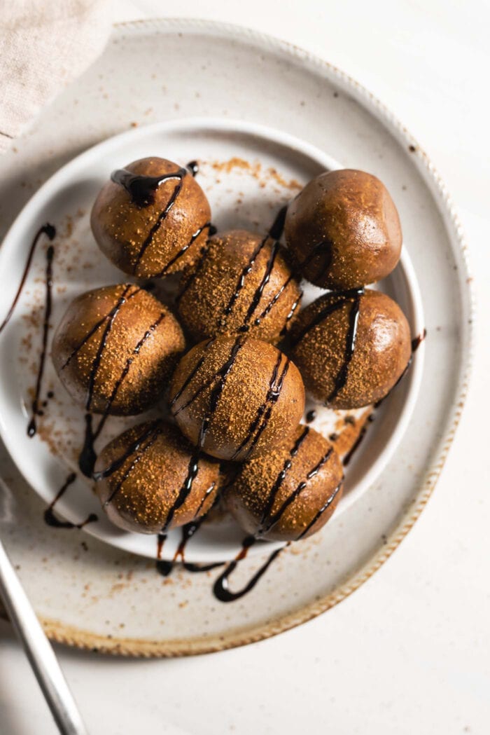 Overhead view of a plate of gingerbread energy. balls drizzled with molasses on a small plate.