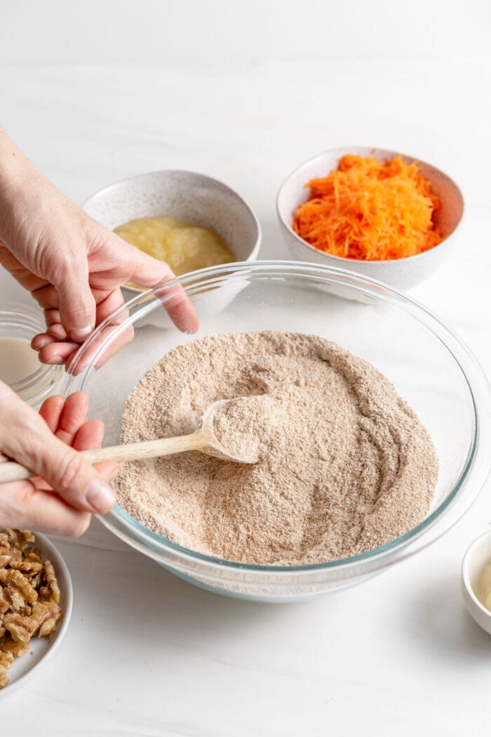 Whisking together flour and other dry baking ingredients in a large mixing bowl.