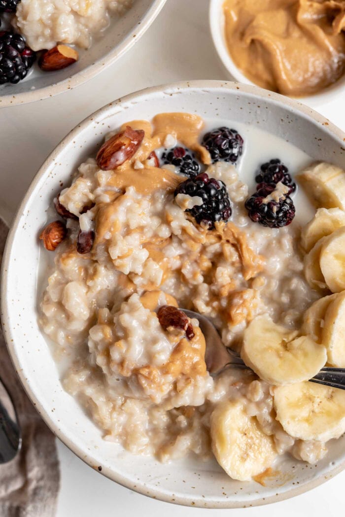 Overhead image of a bowl of oatmeal topped with peanut butter, banana and berries.