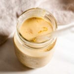 Overhead view of a peanut butter shake in a jar with a straw.