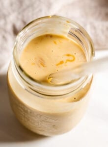 Overhead view of a peanut butter shake in a jar with a straw.