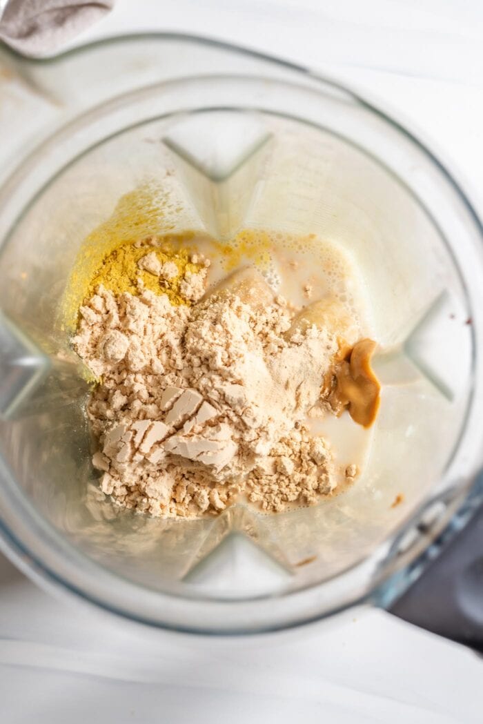 Protein powder, milk and nutritional yeast in a blender.