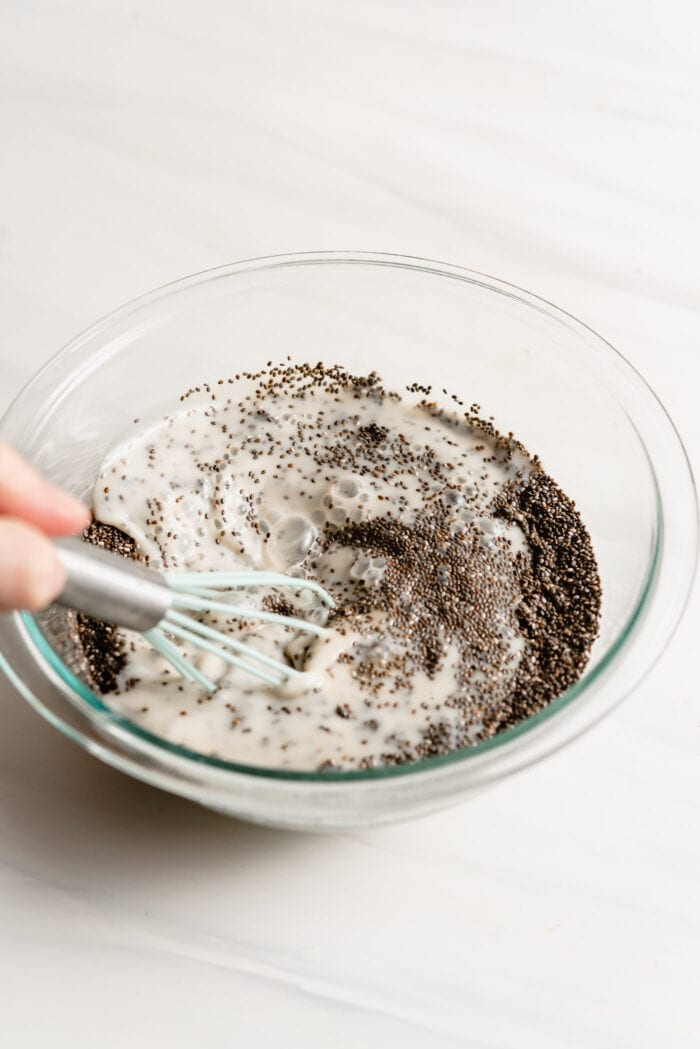 Whisking together milk and chia seeds in a bowl.