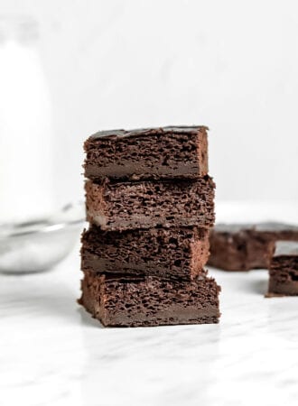 Front view of a stack of 4 sweet potato brownies sitting on a marble surface.
