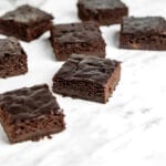 A number of sliced chocolate brownies sitting on a marble surface.