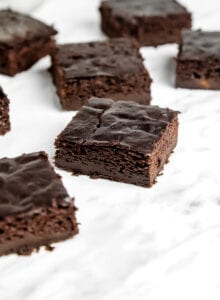 A number of sliced chocolate brownies sitting on a marble surface.