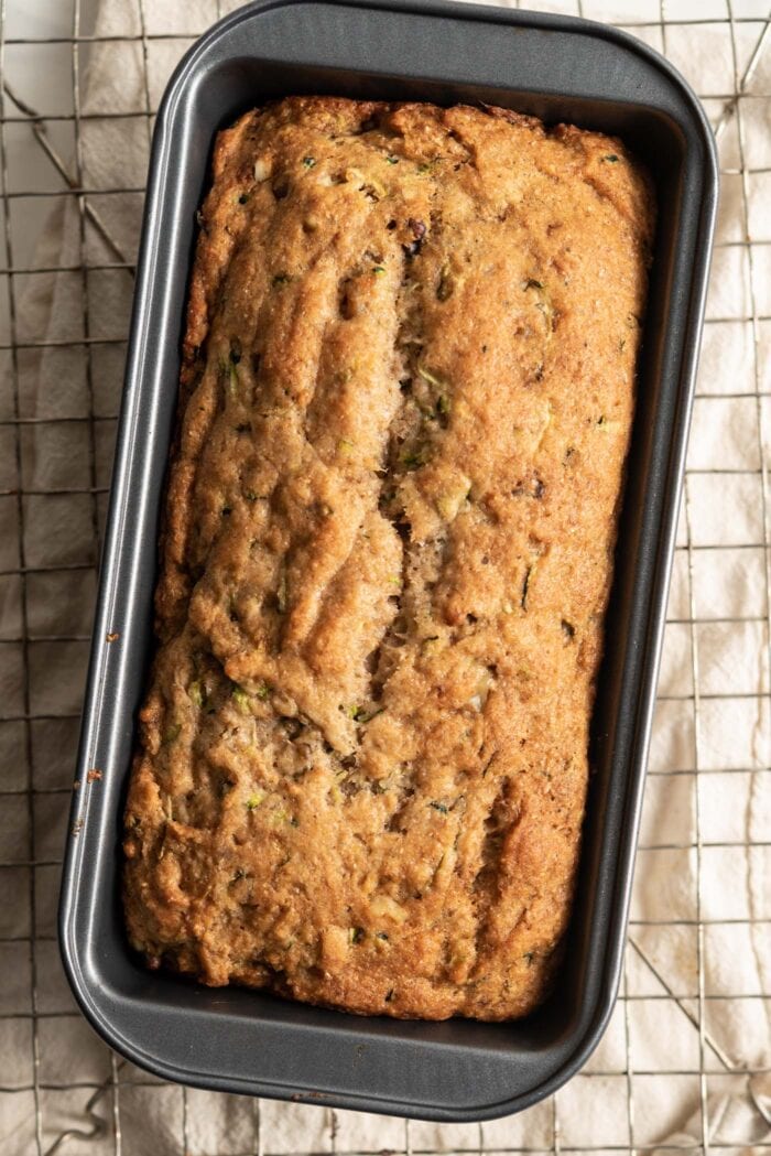 Overhead view of a baked zucchini loaf in a pan.