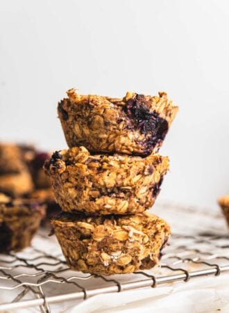 Stack of 3 baked blueberry baked oatmeal cups on a cooling rack.