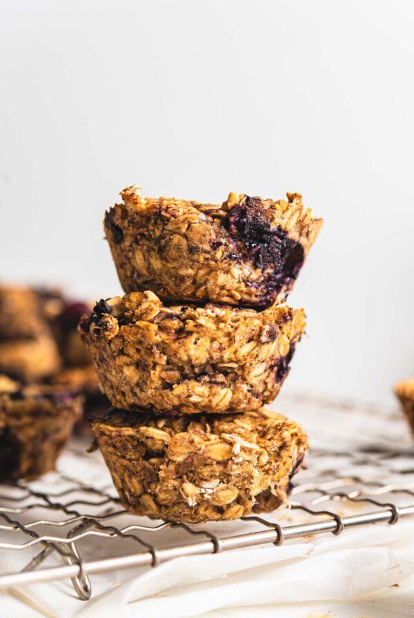 Stack of 3 baked blueberry baked oatmeal cups on a cooling rack.