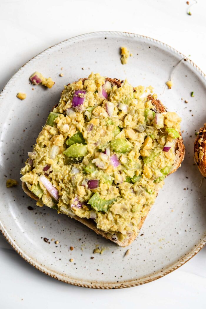 Chickpea salad spread on a piece of bread.