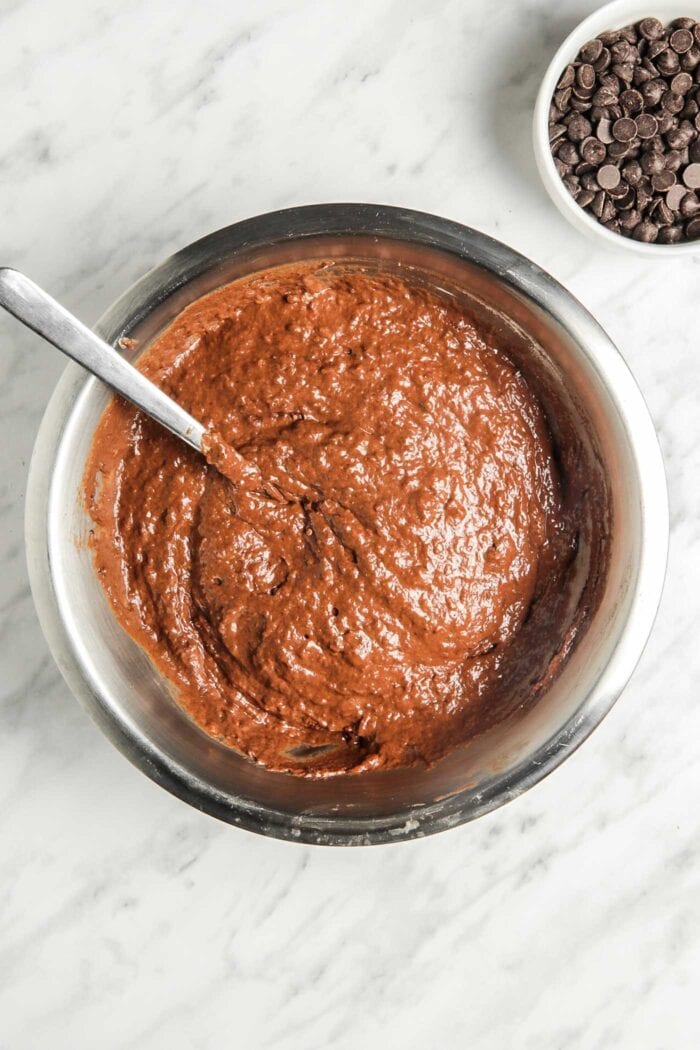 Raw chocolate muffin batter in a metal mixing bowl.