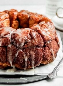 Monkey bread drizzled with icing sugar on a serving tray.