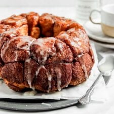 Monkey bread drizzled with icing sugar on a serving tray.