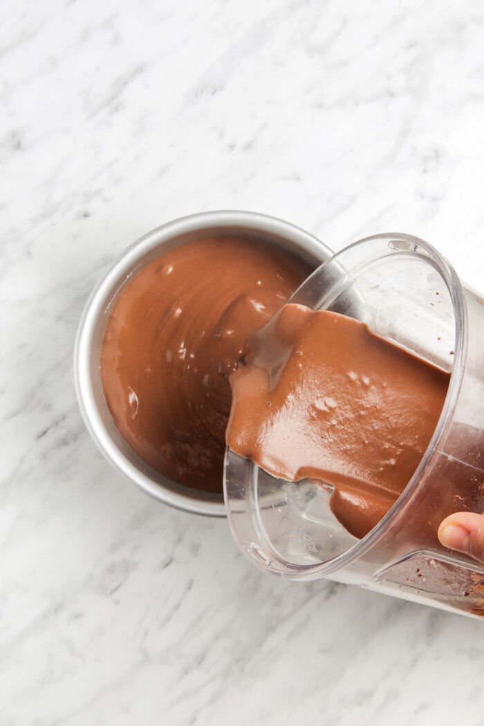 Pour raw chocolate cake batter into a springform pan.