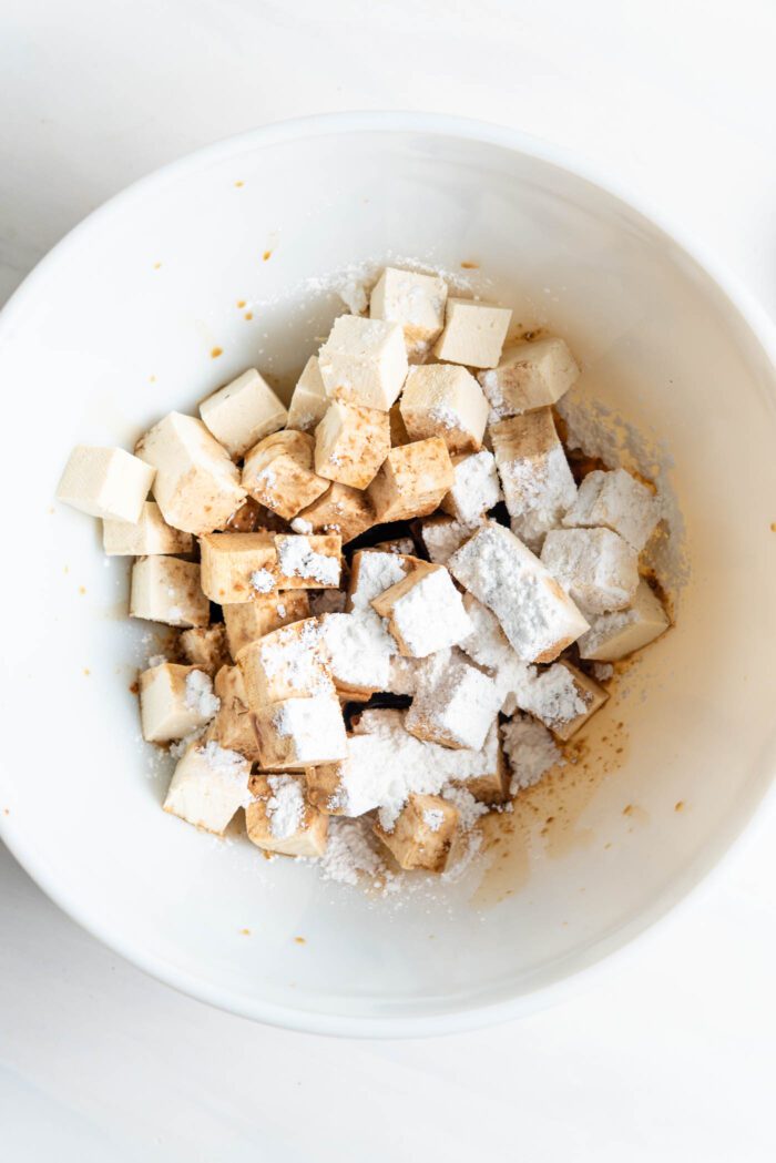 Cubed tofu with cornstarch and soy sauce in a bowl.