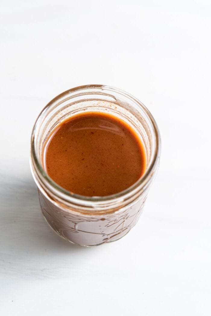 Brown sauce in a small glass jar.
