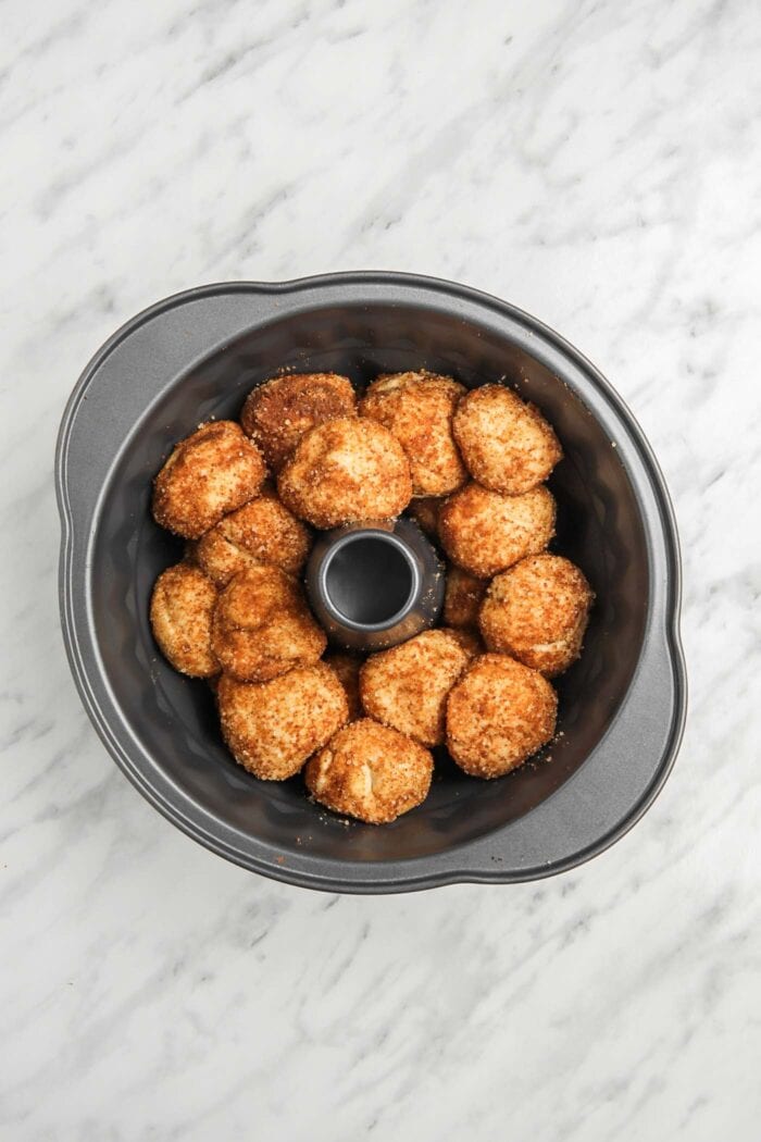 Raw monkey bread dough balls in a bundt pan.