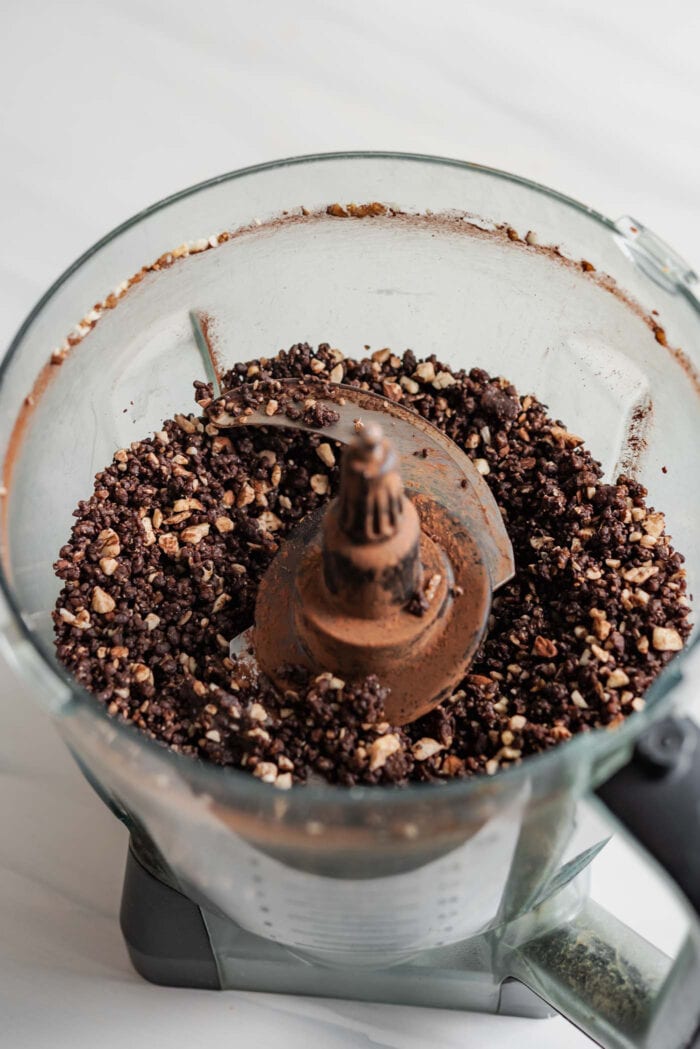 Blended no-bake chocolate dough in a food processor container.
