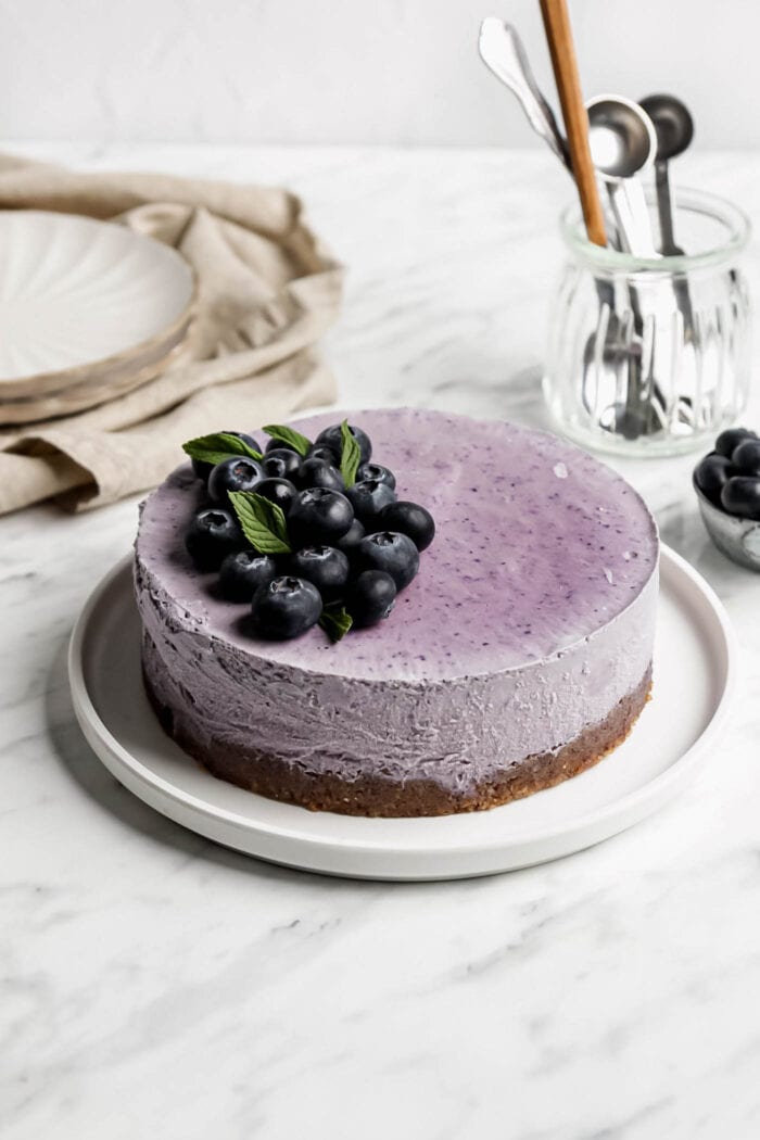 Blueberry cheesecake topped with blueberries on a plate.
