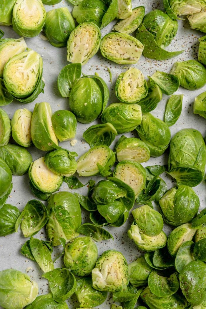 Chopped brussels sprouts on a baking tray lined with parchment paper.