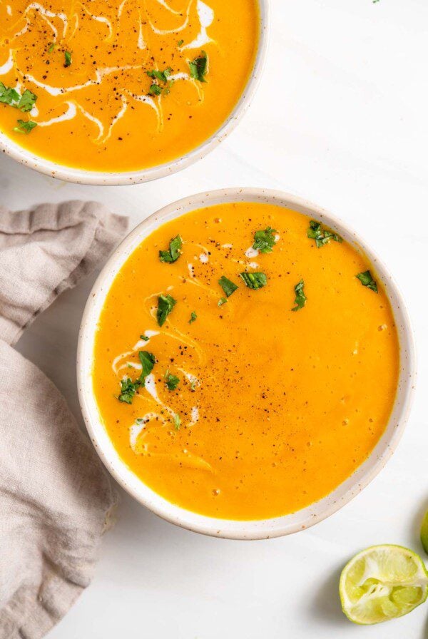 Overhead view of a bowl of butternut squash soup topped with a sprinkle of cilantro.