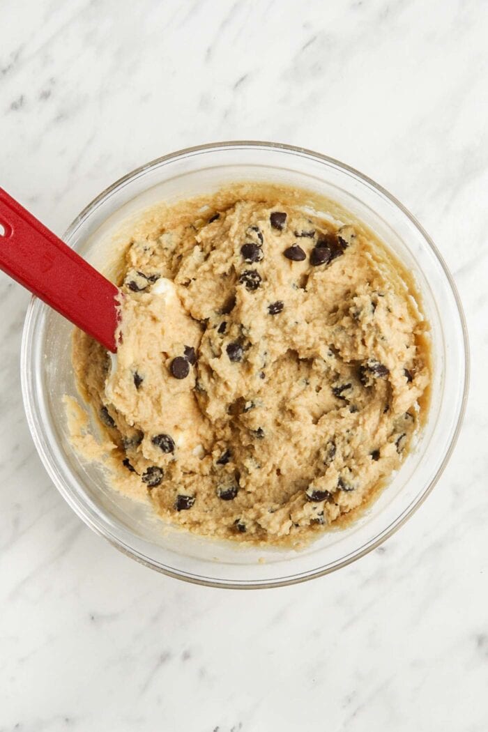 Chocolate chip blondie batter in a bowl with a spatula.