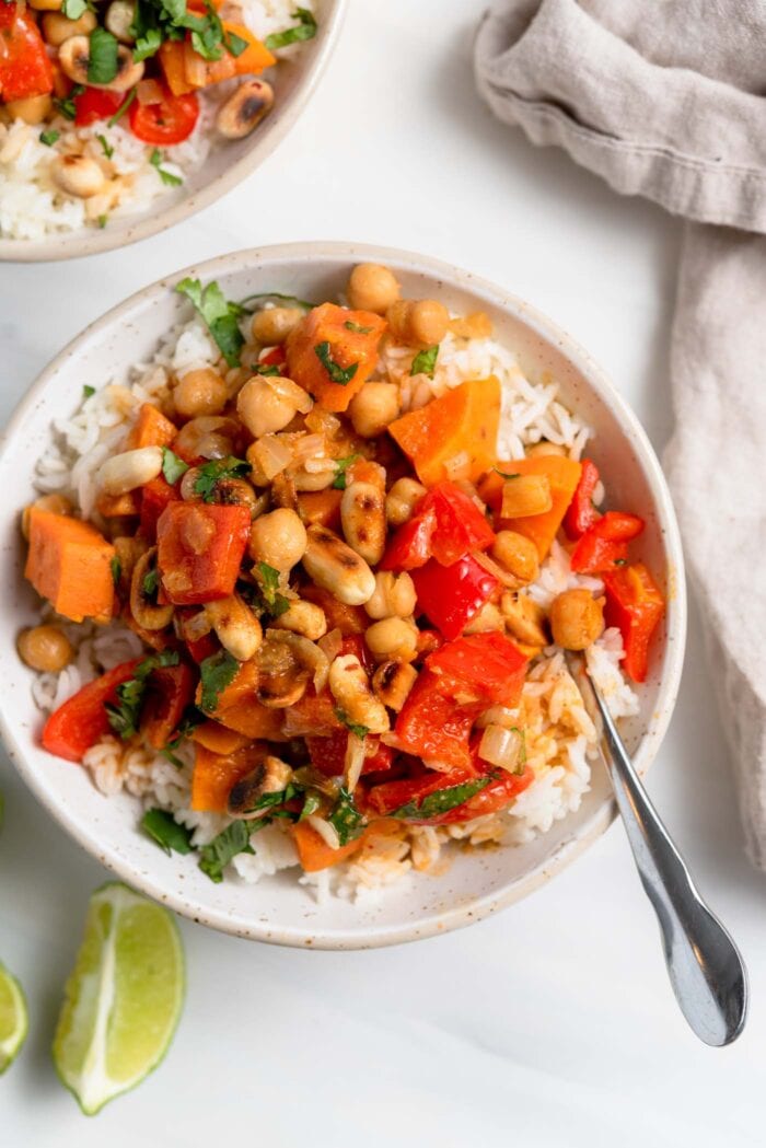 Overhead view of a bowl of sweet potato and chickpea curry topped with peanuts and over rice.