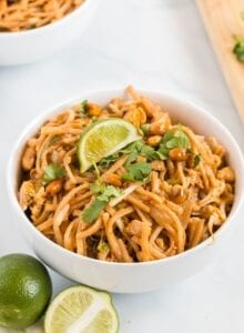 Vegetarian pad thai in a bowl topped with cilantro and a slice of lime.