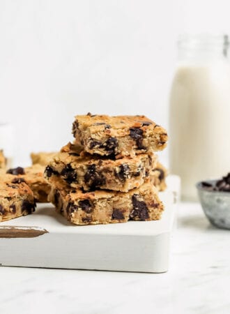 Stack of 3 chocolate chip blondies on a cutting board.