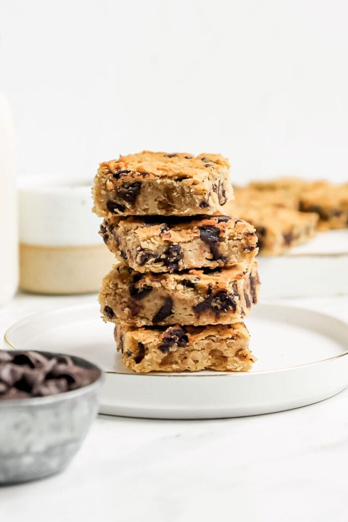 A stack of 4 small squares of chickpea chocolate blondies on a small plate.